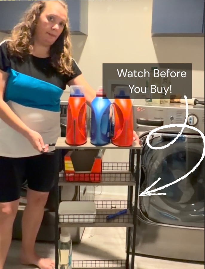Amber beside a slim rolling storage cart between her washer and dryer.